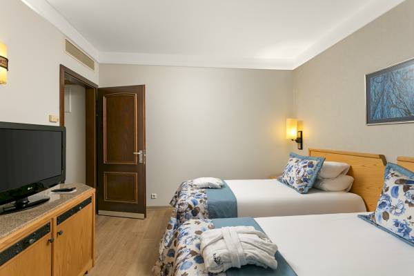 Doppelzimmer im Xanadu Resort Hotel mit zwei Betten, Fernseher und offenem Tür.