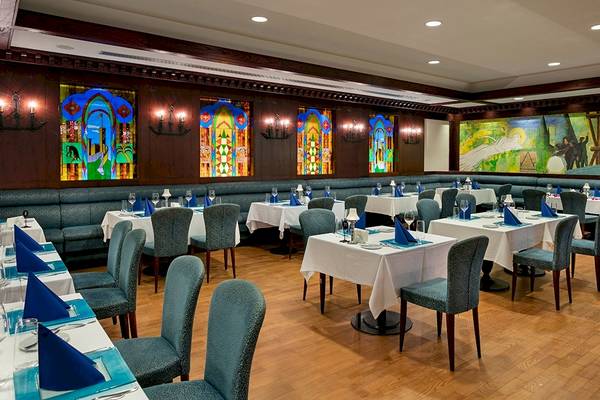 Restaurant im Xanadu Resort Hotel mit blauen Stühlen und bunten Glasfenstern.