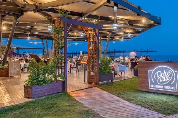 Foto von der Terrasse des Xanadu Resort Hotels mit Blick auf den Ozean und Gäste beim Essen.