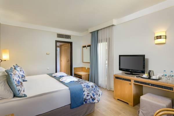 Innenansicht eines Zimmers im Xanadu Resort Hotel mit einem Bett, Fernseher und Schreibtisch.