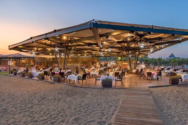 Außenrestaurant des Xanadu Resort Hotels auf dem Strand mit abendlicher Beleuchtung.