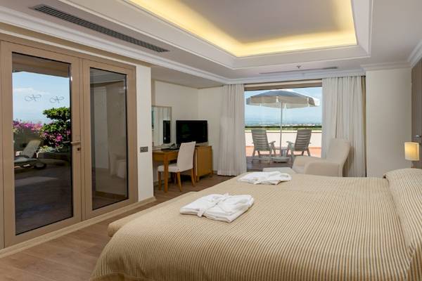 Innenansicht eines Zimmers im Xanadu Resort Hotel mit Balkon, Fernseher und offenem Fenster.