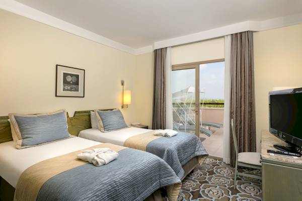 Doppelzimmer im Xanadu Resort Hotel mit zwei Betten, Fernseher und Terrasse.