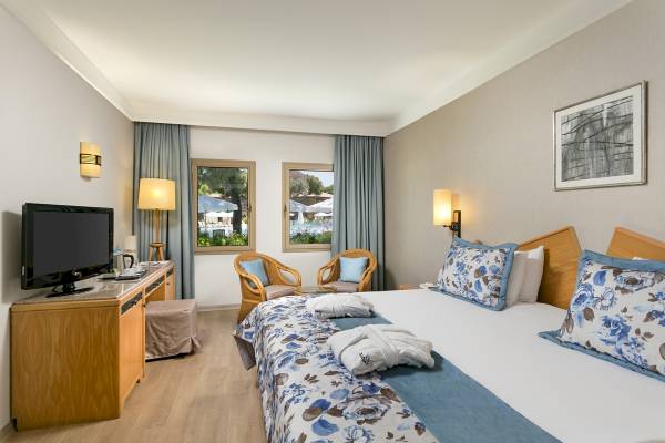 Xanadu Resort Hotel Zimmer mit Fernseher, Schreibtisch und zwei Stühlen neben den Fenstern.