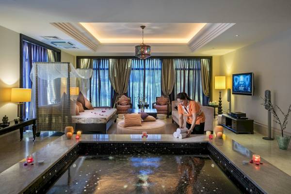 Innenpool und Lounge im Xanadu Resort Hotel mit einer Dame, die Handtücher vorbereitet.