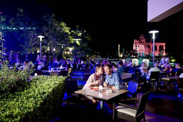 Paar, das abends im Garten des Xanadu Resort Hotels isst und trinkt.
