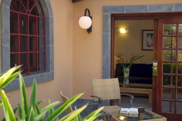 Außenbereich des Hotels Suites & Villas By Dunas mit Möbeln und Pflanzen.