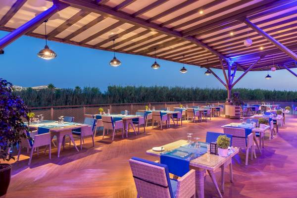 Terrasse des Xanadu Resort Hotels bei Nacht mit blauer Beleuchtung und Tischen