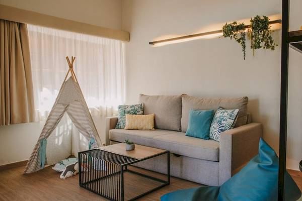 Wohnzimmer im Suites & Villas By Dunas Hotel mit grauem Sofa, Beistelltisch und Zelt.