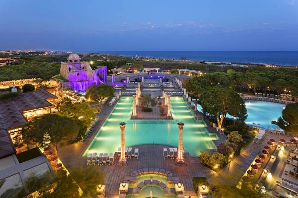 Xanadu Resort Hotel Außenansicht bei Abend mit beleuchtetem Pool und Meer im Hintergrund.