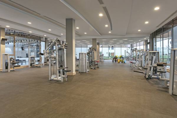 Fitnesscenter im Xanadu Makadi Bay Hotel mit vielen Geräten und großen Fenstern.