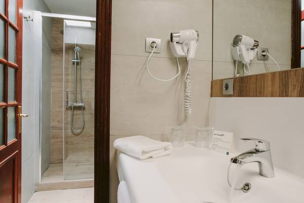 Badezimmer mit Dusche, Föhn und Waschbecken im Suites & Villas By Dunas Hotel