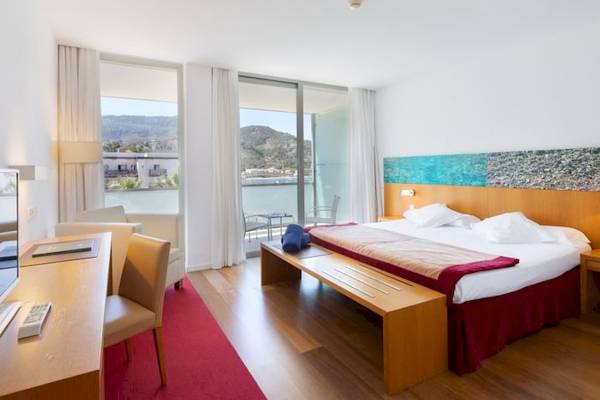 Ein modernes Hotelzimmer im Aimia Hotel mit Blick auf das Meer und Berge.