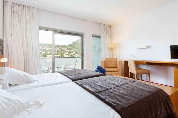 Schlafzimmer im Aimia Hotel mit zwei Betten, Blick auf die Stadt und Möbeln.