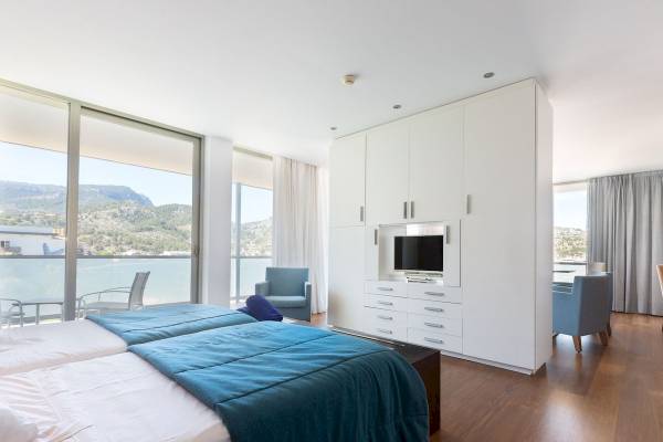 Schlafzimmer im Aimia Hotel mit zwei Betten und Blick auf die Berge.
