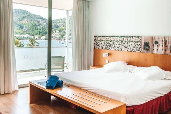 Schlafzimmer im Aimia Hotel mit Blick auf das Meer und eine Stadtlandschaft