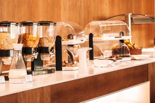 Frühstücksbuffet im Aimia Hotel mit Müsli, Früchten und Gebäck.