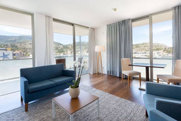 Wohnzimmer des Aimia Hotels mit Blick auf das Meer, voll möbliert mit Sofas, Tisch, Stühlen und einer Pflanze.