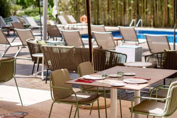 Außenterrasse des Aimia Hotels mit einem Tisch, auf dem Speisen serviert sind.