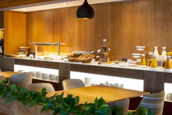 Frühstücksbuffet im Aimia Hotel mit verschiedenen Gerichten und Getränken.