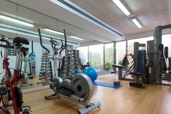 Innenansicht des Fitnesscenters des Aimia Hotels mit verschiedenen Trainingsgeräten und Geräten.