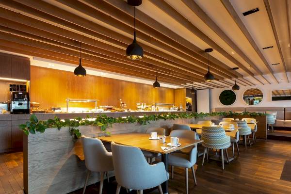 Innenansicht des Restaurants im Aimia Hotel mit Holzböden und modernen Möbeln.
