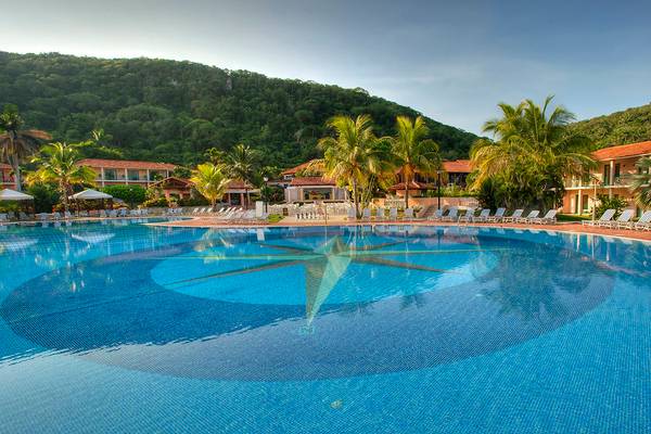 Außenpool des Memories Jibacoa Resorts mit Liegestühlen und Palmen im Hintergrund