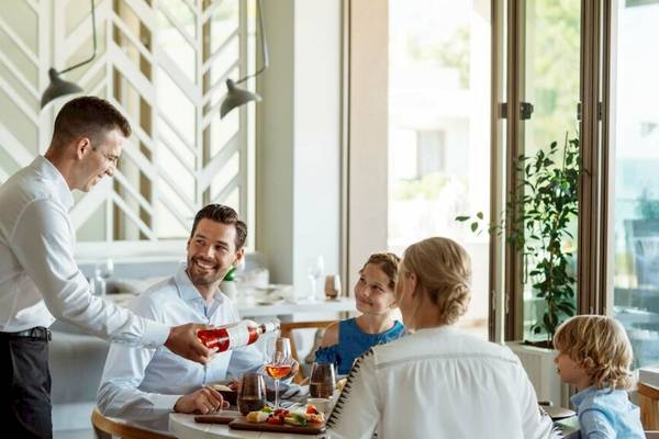 Eine Familie im Restaurant bei einem Essen im Ikos Dassia.