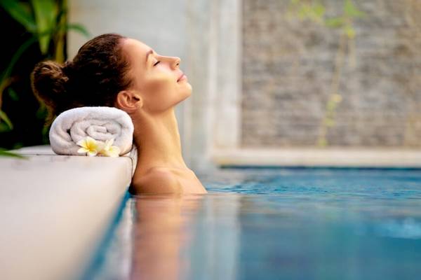Frau im Pool mit Blick zum Himmel, Entspannung im Freien.