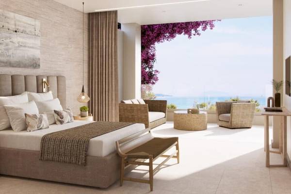 Schlafzimmer im Ikos Odisia Hotel mit Blick auf das Meer und die Küste.