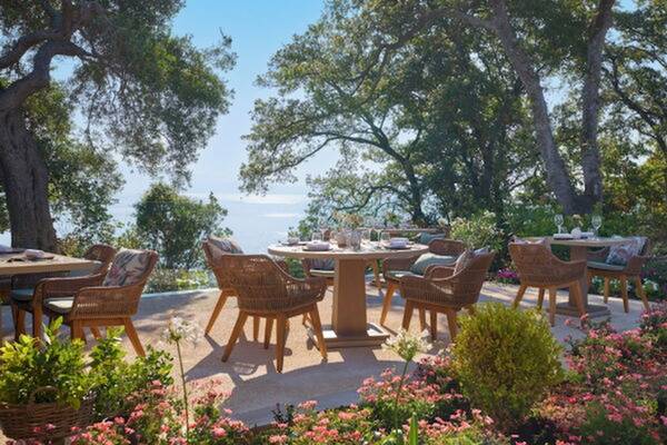 Gartensitzplatze mit Tischen und Stühlen im Freien im Ikos Odisia Hotel