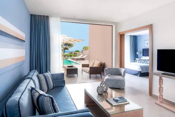 Ein modernes Hotelzimmer mit Blick auf einen Pool im Ikos Olivia Hotel.