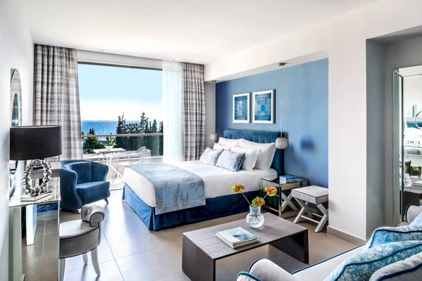 Innenansicht eines Hotelzimmers im Ikos Olivia Hotel mit Blick auf das Meer.