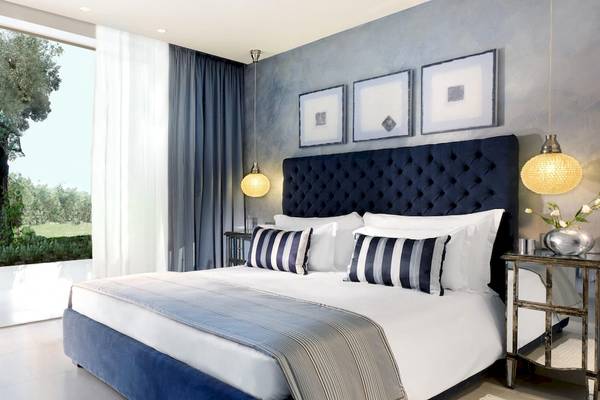 Schlafzimmer im Ikos Olivia Hotel mit Blick auf einen Garten.