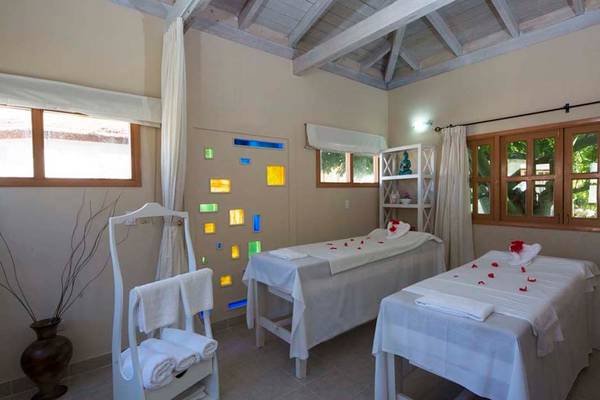 Spa-Behandlungsraum im Memories Jibacoa Resort mit zwei Massagetischen und Fenstern.