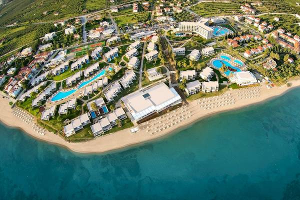 Luftaufnahme des Ikos Olivia Hotels mit Pool, Strand und Gebäuden.