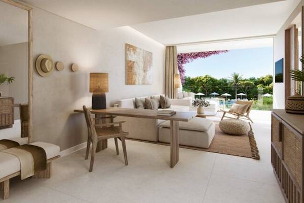 Wohnzimmer des Ikos Porto Petro Hotels mit Blick auf die Terrasse und Außenpool.