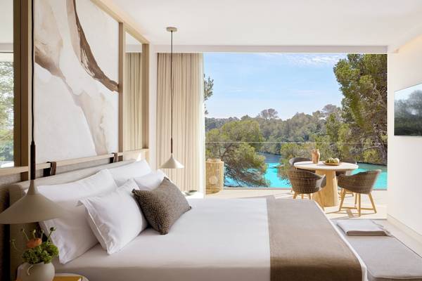Suite Zimmer im Ikos Porto Petro Hotel mit Aussicht auf den Pool und die Landschaft.