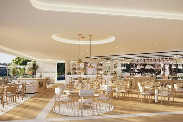 Innenansicht des Restaurants im Ikos Porto Petro Hotel mit modernen Möbeln und Holzböden.