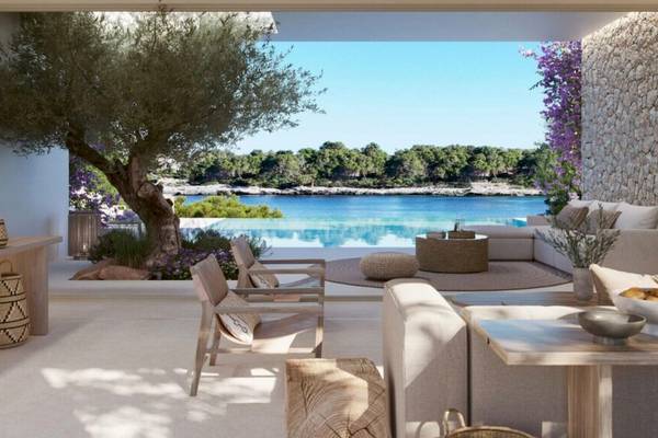 Wohnbereich mit Möbeln, Blick auf Pool und Meer im Hintergrund, Ikos Porto Petro Hotel