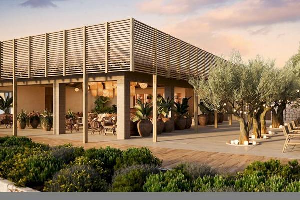 Außenbereich des Ikos Porto Petro Hotels mit Holzterrasse und beleuchteten Bäumen