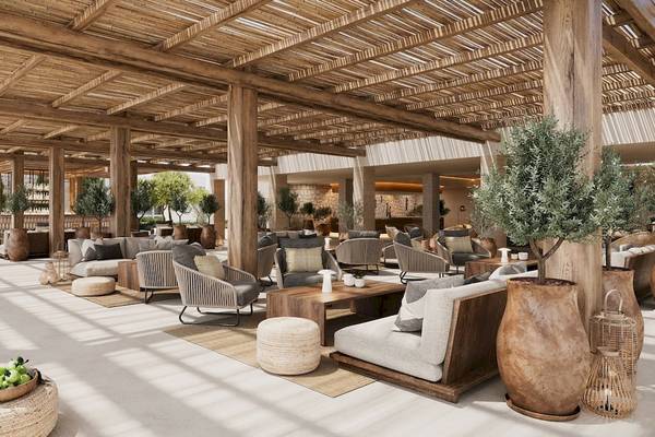 Loungebereich des Ikos Porto Petro Hotels mit Holzmöbeln und Pflanzen.