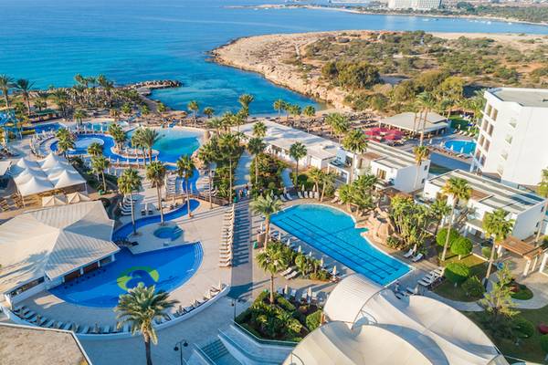 Luftaufnahme des Adams Beach Hotel Resorts mit Swimmingpools, Sonnenliegen und Palmen
