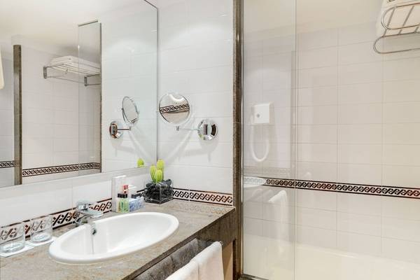 Badezimmer im H10 Blue Mar Boutique Hotel mit Waschbecken, Spiegel und Dusche.