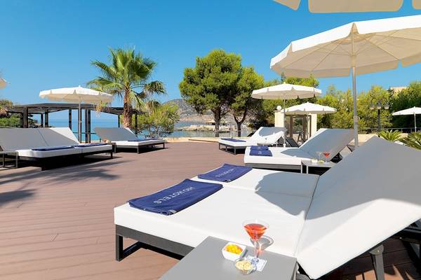 Terrasse des H10 Blue Mar Boutique Hotels mit weißen Liegen und Sonnenschirmen, Blick auf das Meer