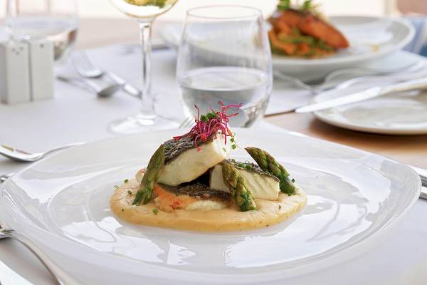 Fischgericht auf einem weißen Teller im H10 Blue Mar Boutique Hotel Restaurant