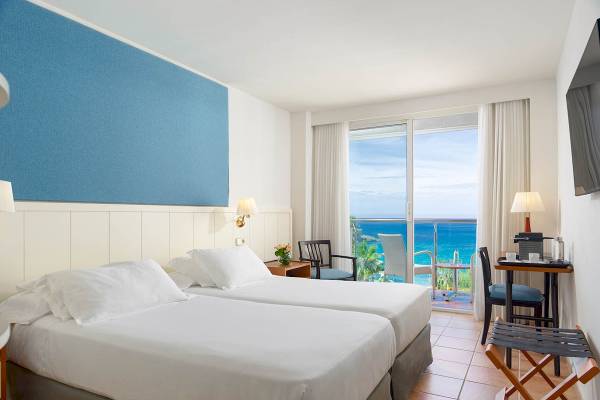 Doppelzimmer mit Meerblick im H10 Blue Mar Boutique Hotel mit zwei Betten, Aussichtsfenster und Balkon.