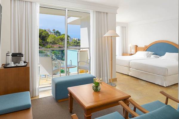 Innenansicht der Suite im H10 Blue Mar Boutique Hotel mit Blick auf die Außenterrasse und den Pool.