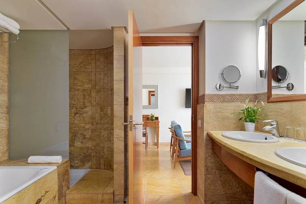Badezimmer im H10 Blue Mar Boutique Hotel mit Badewanne, Dusche, Waschbecken und Möbeln.