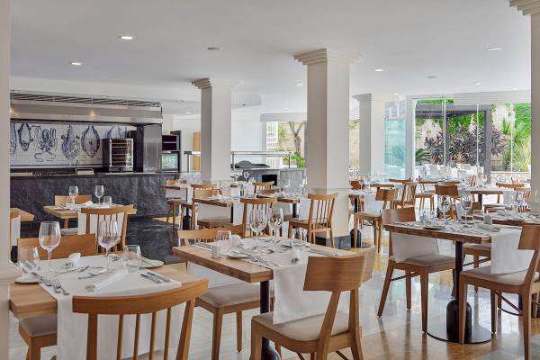 Innenansicht des Restaurants im H10 Blue Mar Boutique Hotel mit gedeckten Tischen und Stühlen.